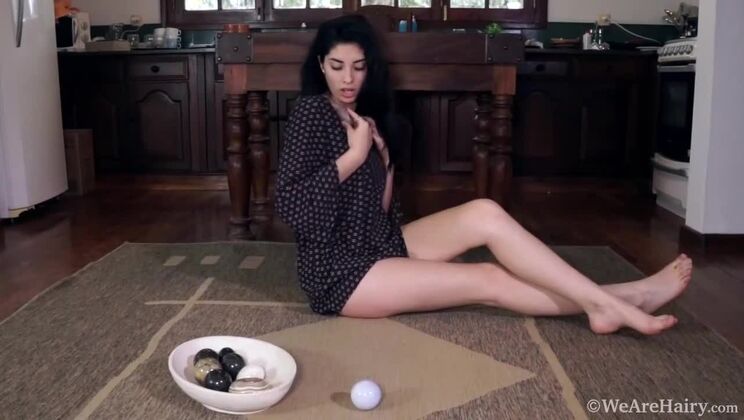 Ornella plays with stones on her hairy slit